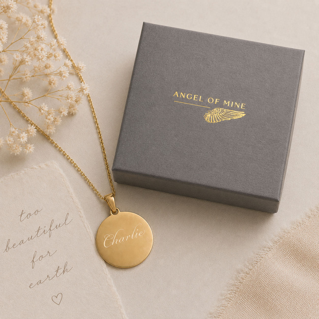 Gold necklace with a pendant on a 'Angel of Mine' branded box.