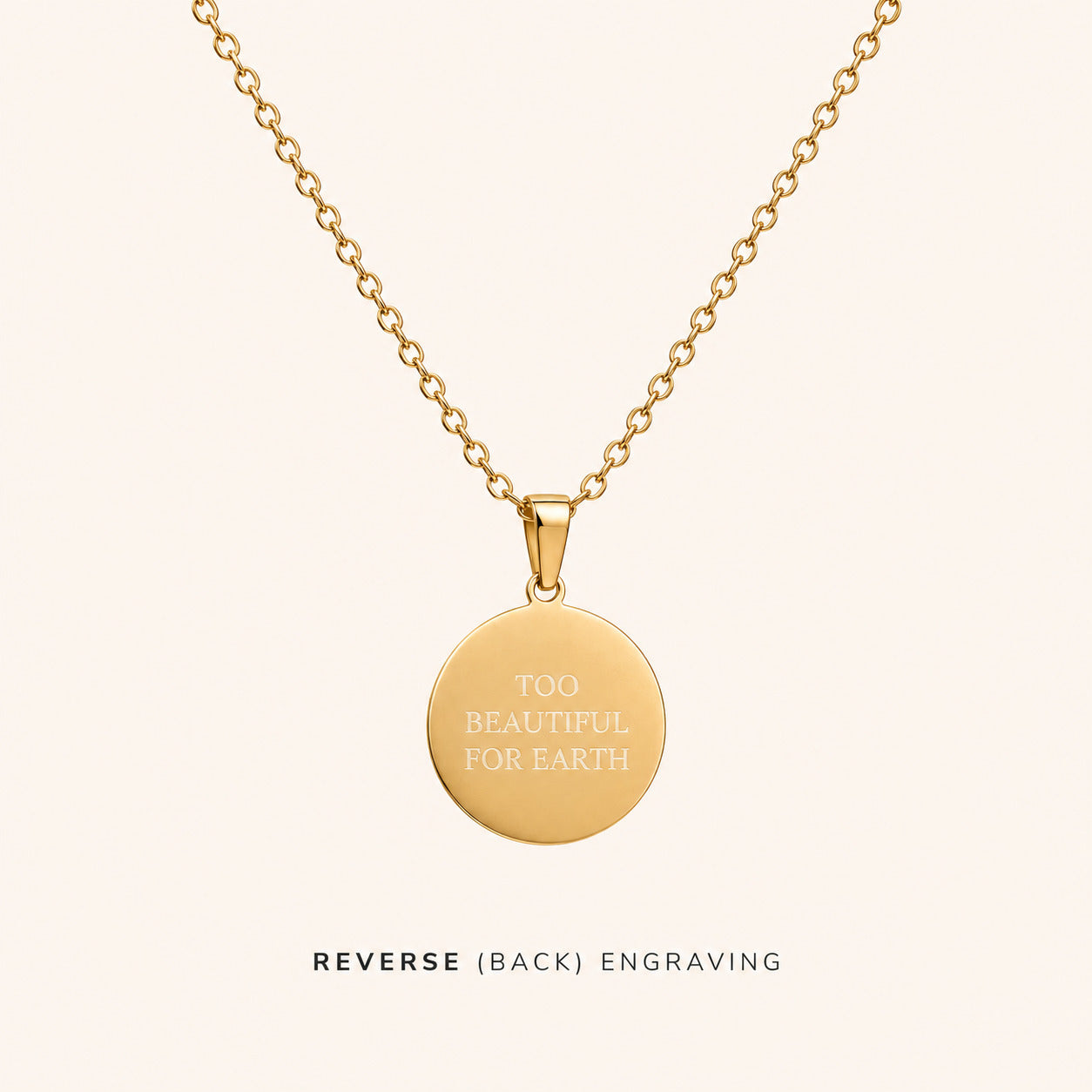 Gold necklace with a round pendant engraved with 'TOO BEAUTIFUL FOR EARTH' on a white background.
